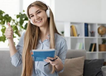 Chica estudiando idiomas con auriculares y libreta