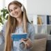 Chica estudiando idiomas con auriculares y libreta
